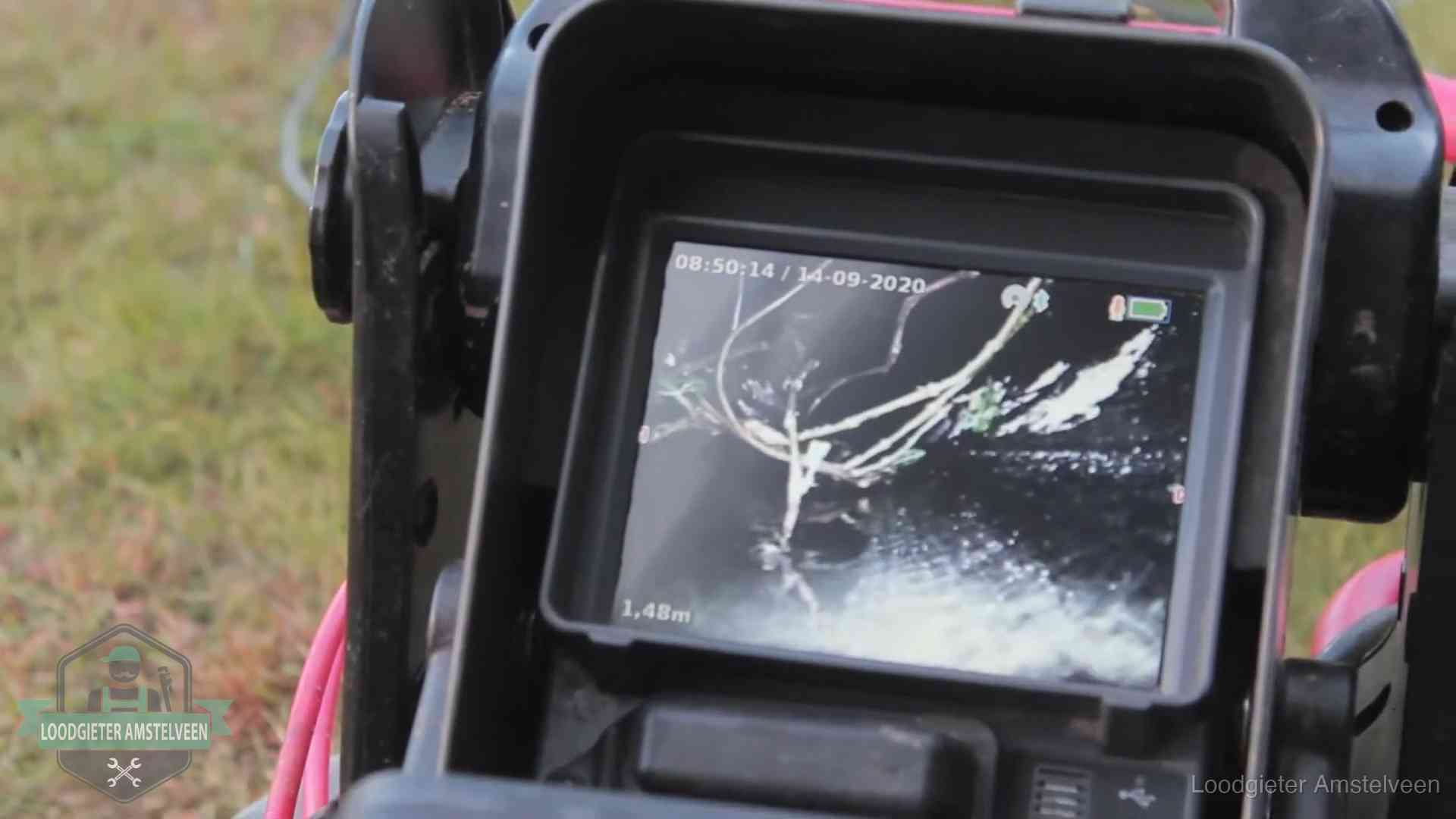 Monitor van een rioolcamera toont wortelingroei in de rioolbuis bij een woning in Amstelveen