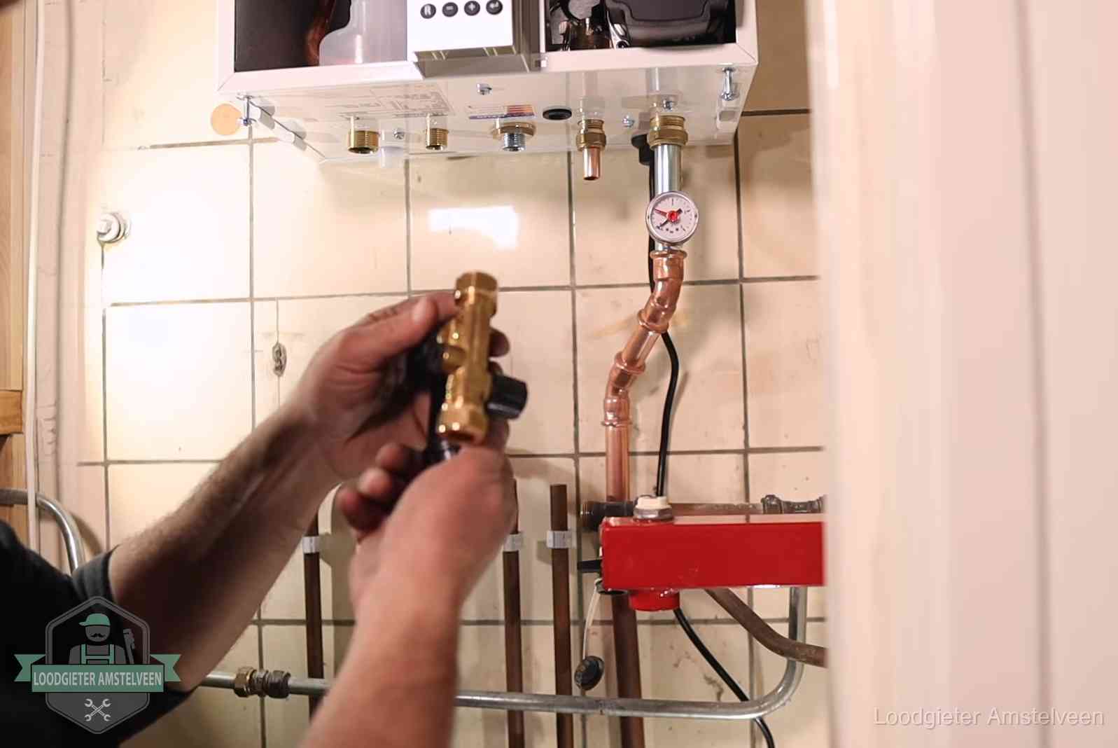Vulkraan en manometer onder een cv-ketel voor het bijvullen van de waterdruk in Amstelveen