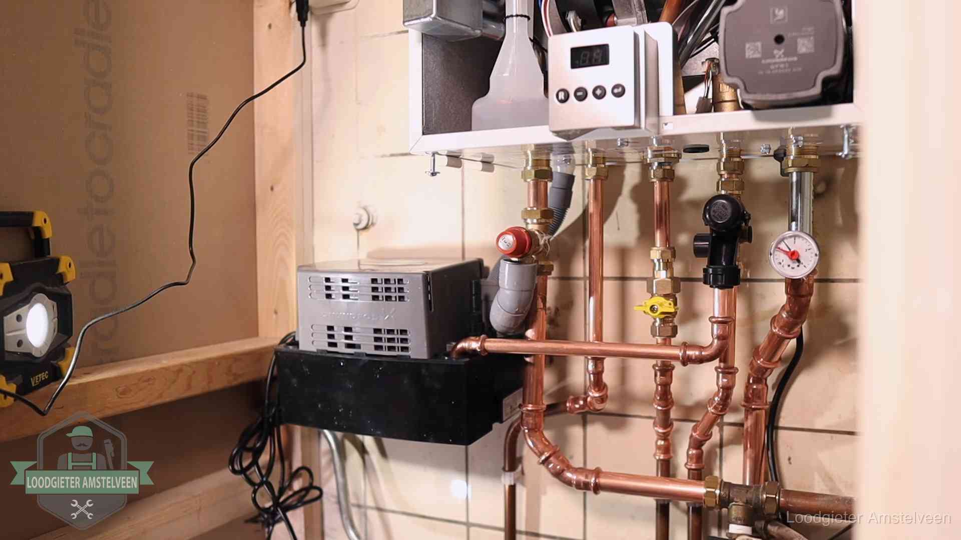 Nieuw koperen leidingwerk met pomp en manometer onder een vervangen cv-opstelling in Amstelveen