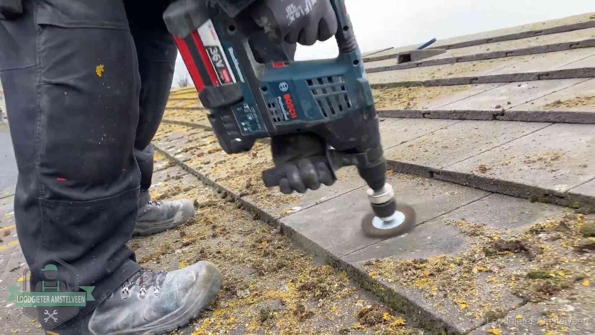 Betonnen dakpannen worden machinaal gereinigd tijdens dakonderhoud in Amstelveen