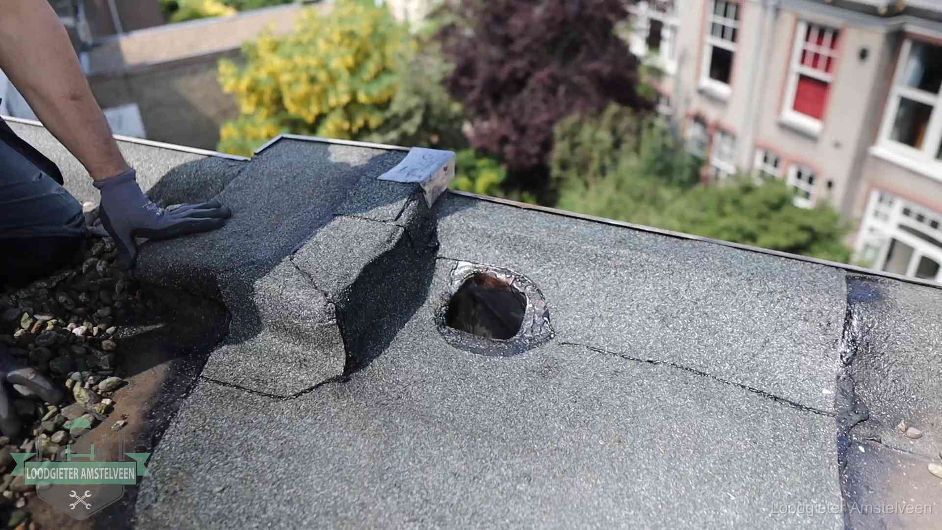 Loodgieter inspecteert een beschadigd bitumen plat dak tijdens een daklekkage-inspectie in Amstelveen