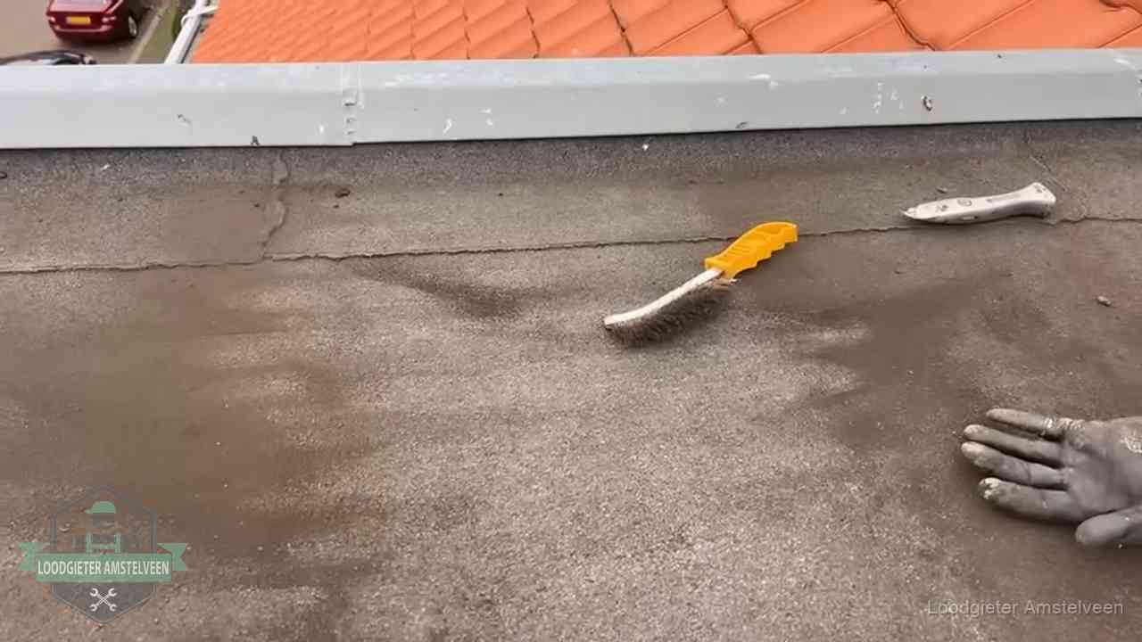Dakdekker bereidt een bitumen plat dak voor op reparatie bij de daktrim in Amstelveen