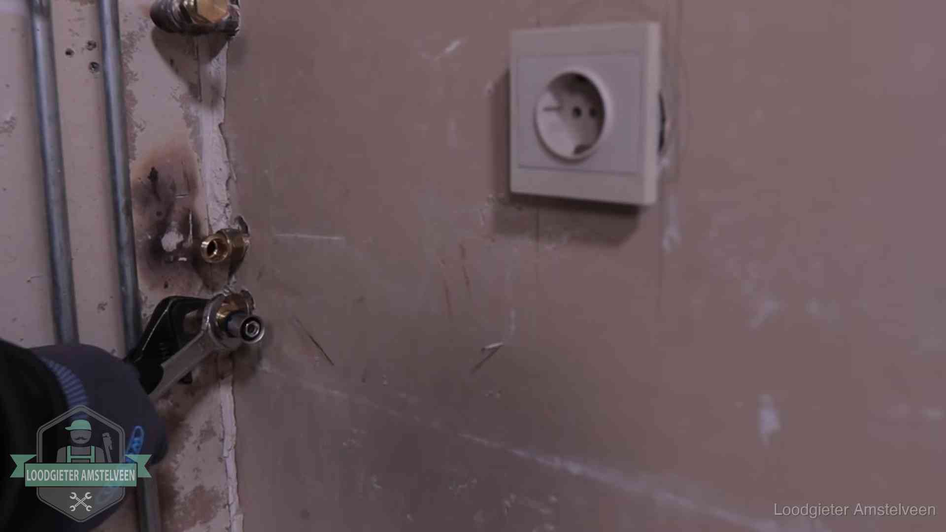 Erkend vakmanschap in Amstelveen Monteur draait een perskoppeling vast op een leidingaansluiting in Amstelveen