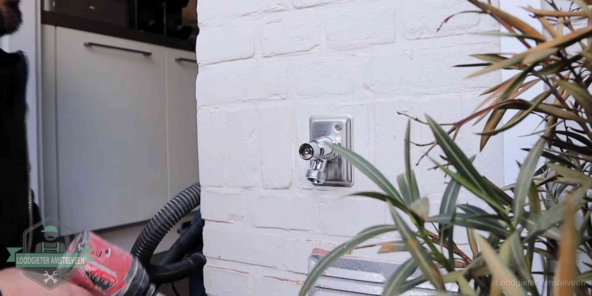 Chromen kraan op een muurplaat bij een woning in Amstelveen, dichtdraaien is stap een van de lektest