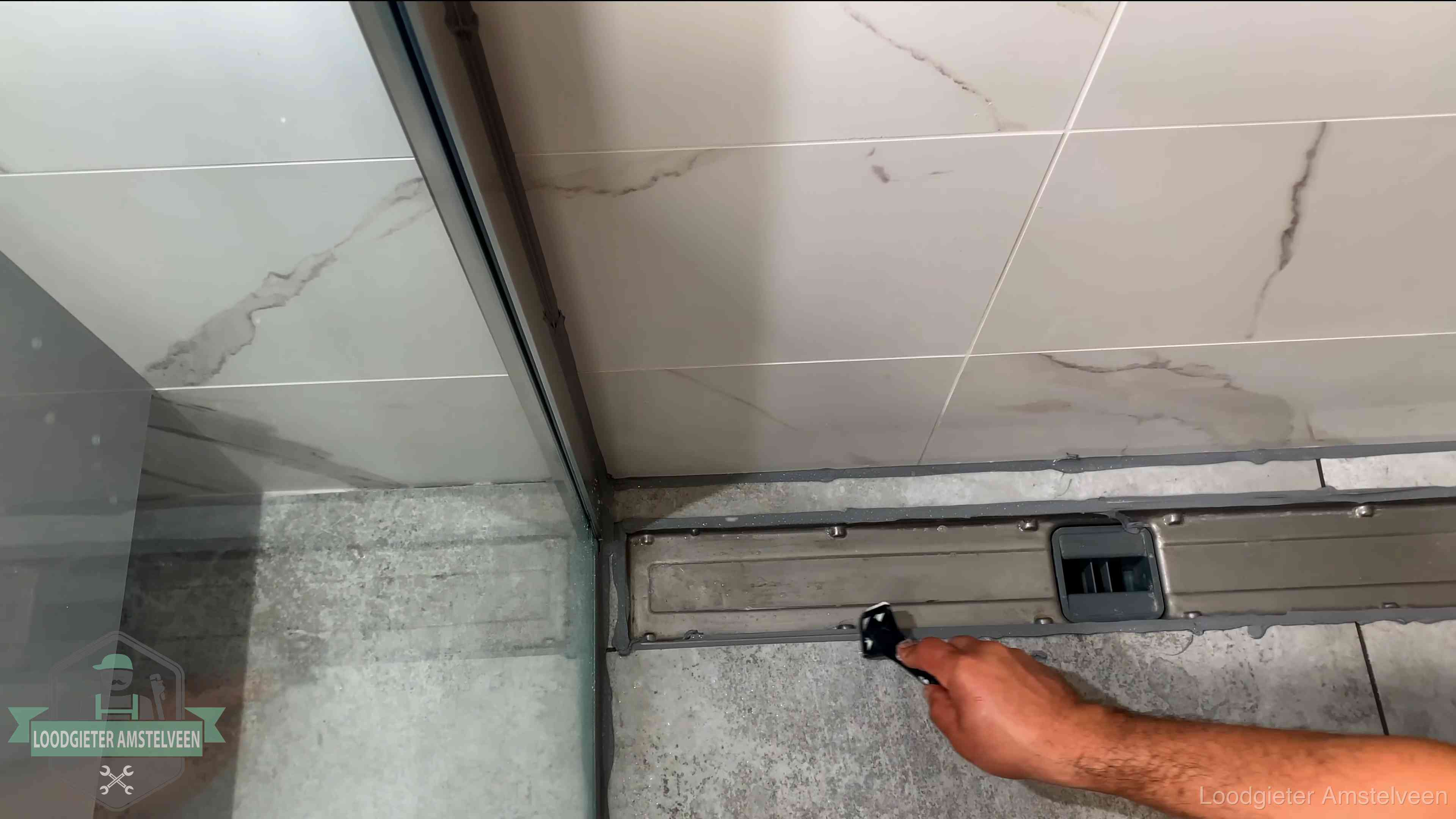 Lekkage in de badkamer verhelpen in Amstelveen Verse kitrand langs de douchegoot in een betegelde badkamer in Amstelveen