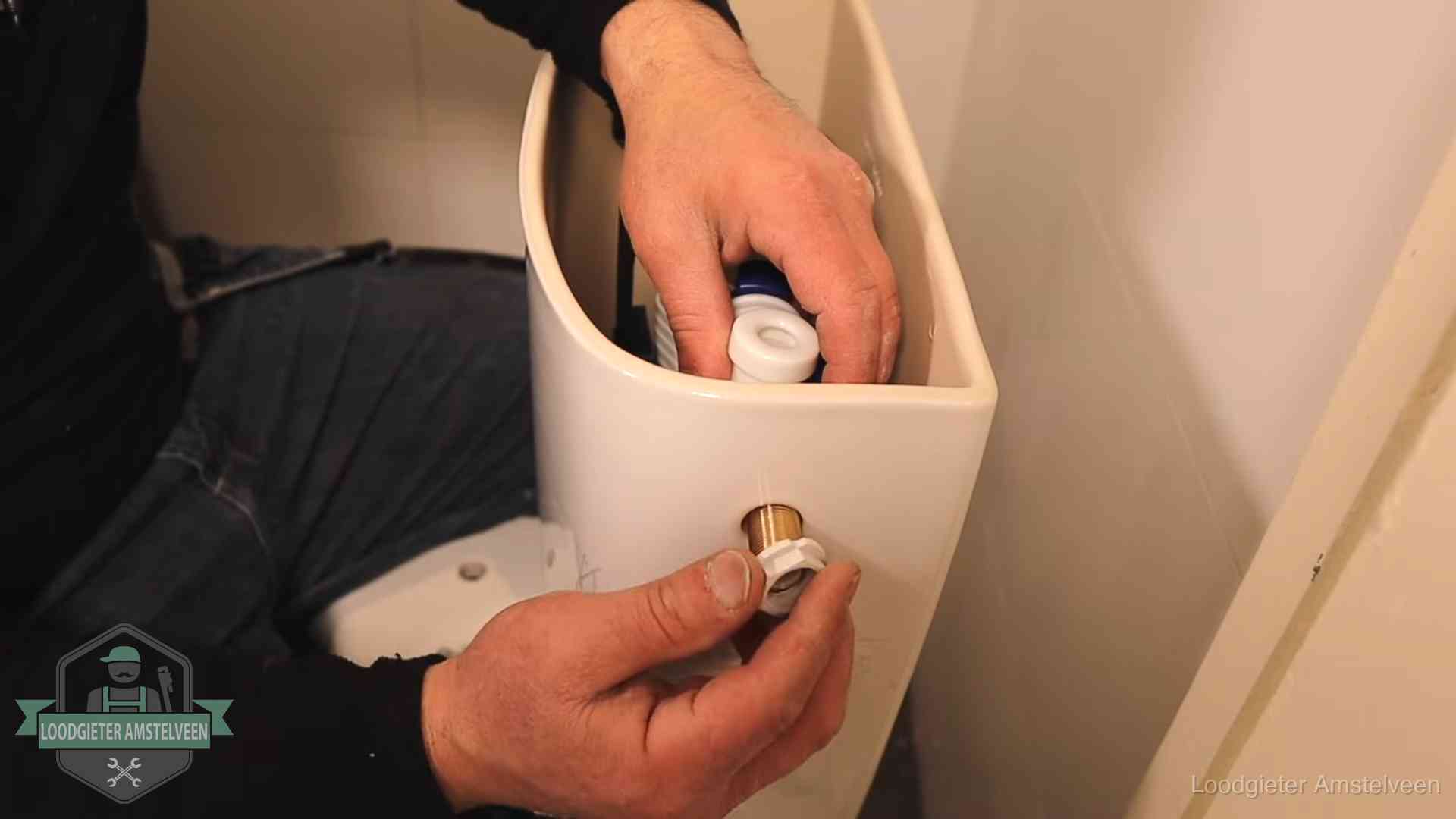 Loodgieter voor je verstopte wc in Amstelveen Loodgieter monteert de vlotterkraan van een stortbak bij een toilet in Amstelveen