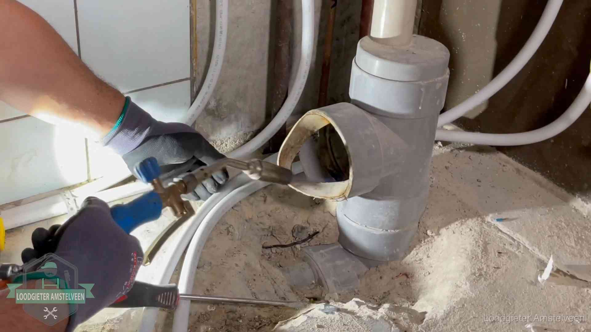 Vakmanschap van onze loodgieters in Amstelveen Loodgieter werkt met brander en messing kraanwerk aan leidingen in Amstelveen