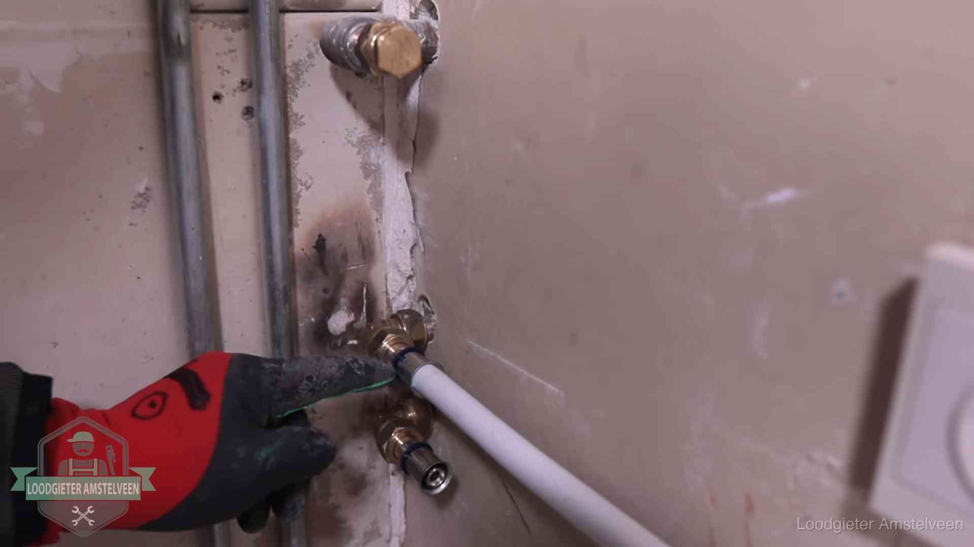 Garantie op loodgieterswerk in Amstelveen Loodgieter wijst de persfitting op nieuwe muuraansluitingen aan in een woning in Amstelveen