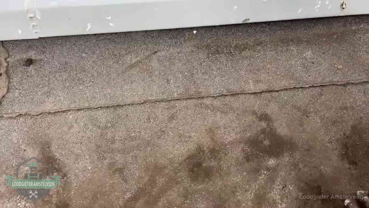 Vochtplekken bij de naad van een plat dak na aanhoudende regen in Amstelveen