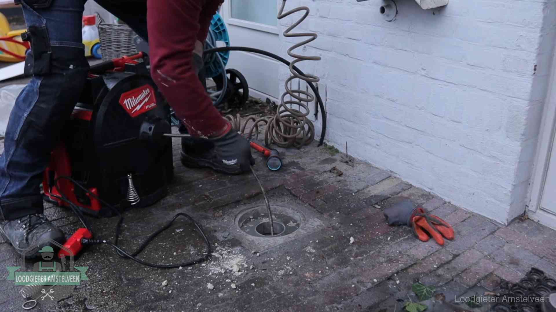 Spiraalmachine bij een ontstoppingsputje in de bestrating in Amstelveen