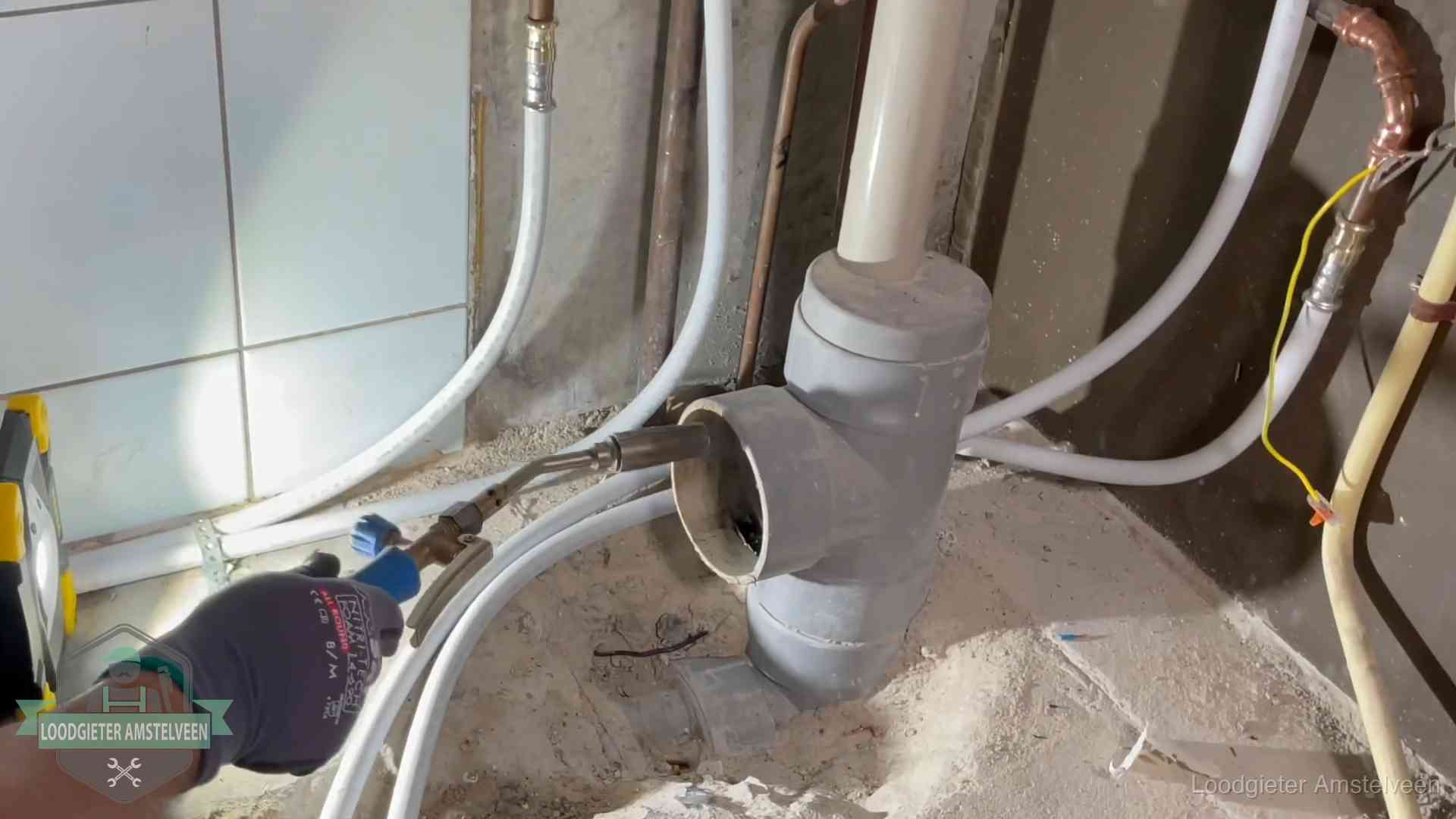 Loodgieter werkt aan leidingen bij de pvc-standleiding van een huurwoning in Amstelveen
