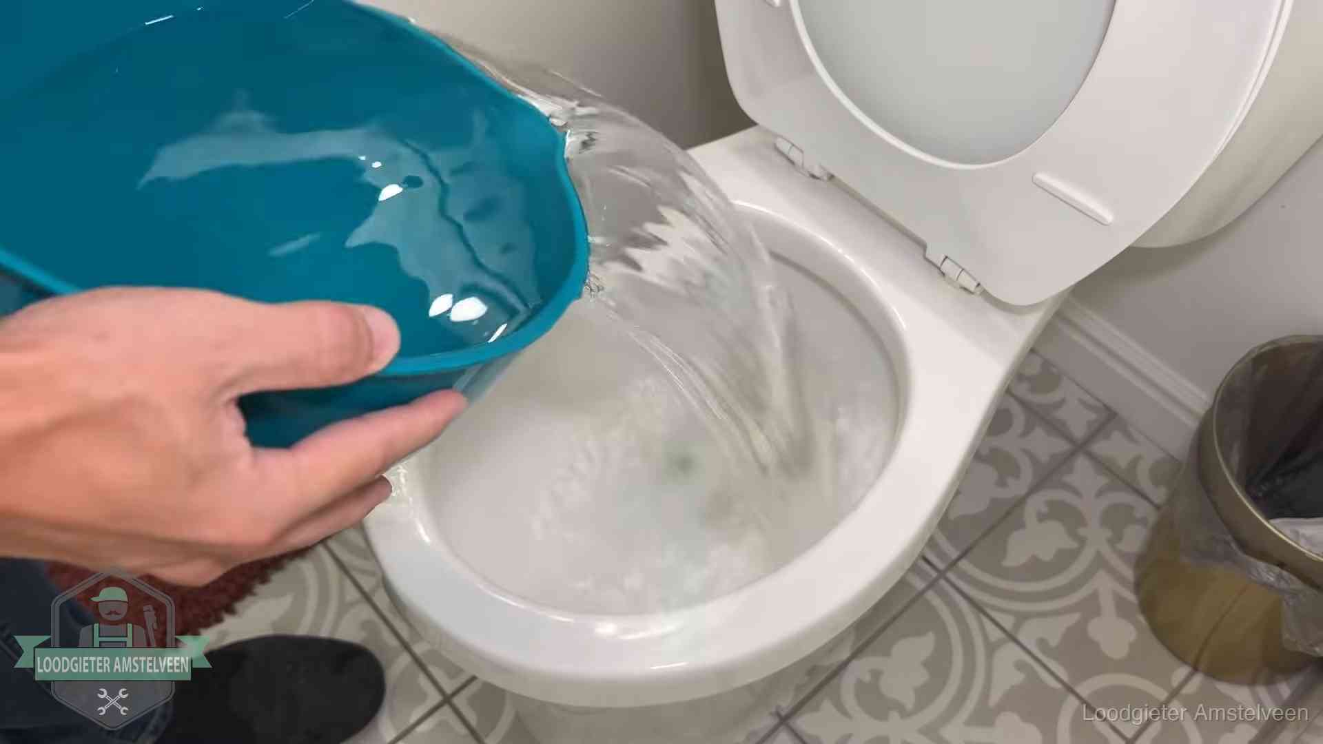 De warm-water-methode in Amstelveen Warm water wordt voorzichtig in de wc-pot gegoten in Amstelveen