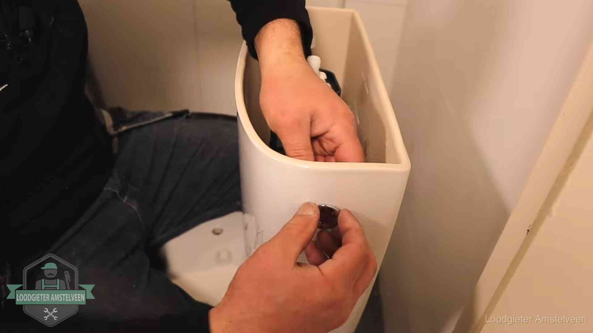 Je wc verstoppingsvrij houden in Amstelveen Drukknop van een duoblok-stortbak wordt gemonteerd bij een toilet in Amstelveen