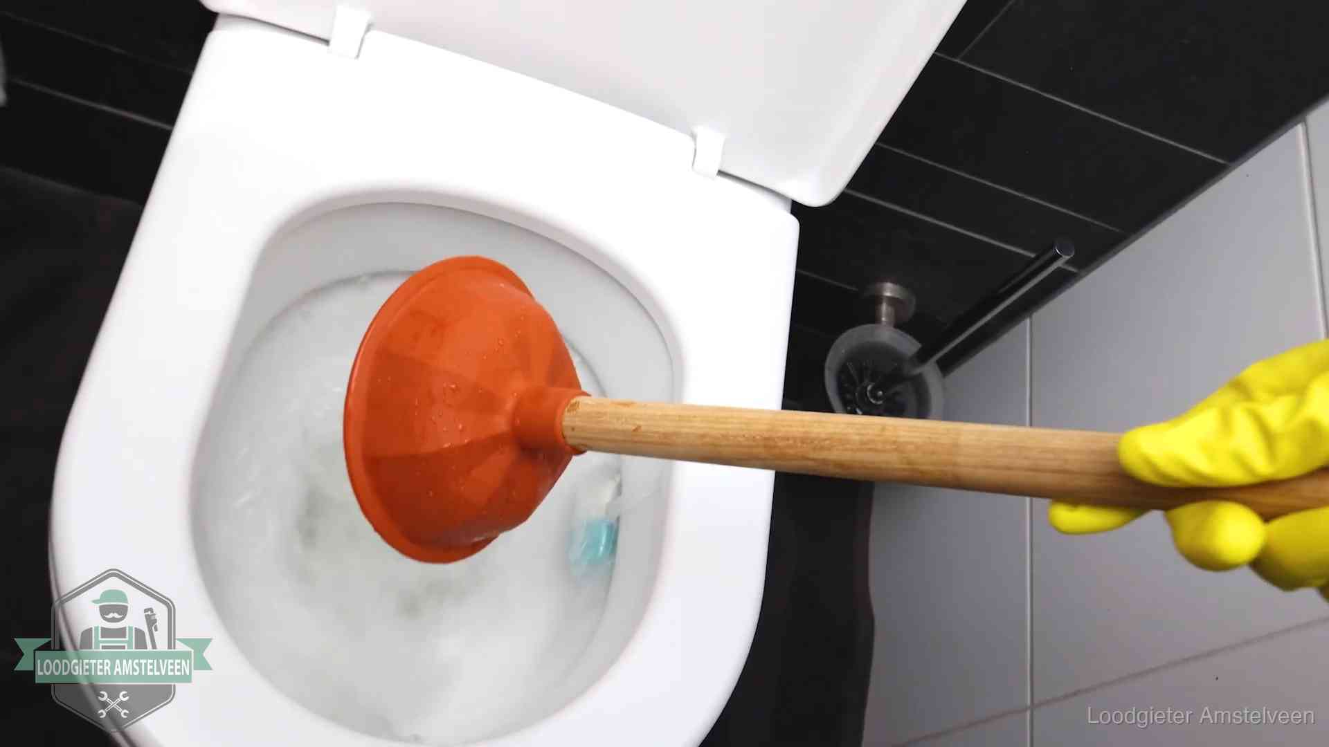 Wc ontstoppen met de plopper in Amstelveen Plopper wordt in de wc-pot gedrukt bij het ontstoppen van een toilet in Amstelveen